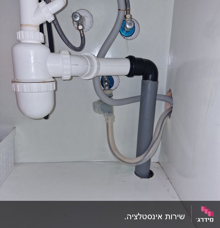 צנרת פלסטיק מתחת לכיור עם חיבורים וברזים